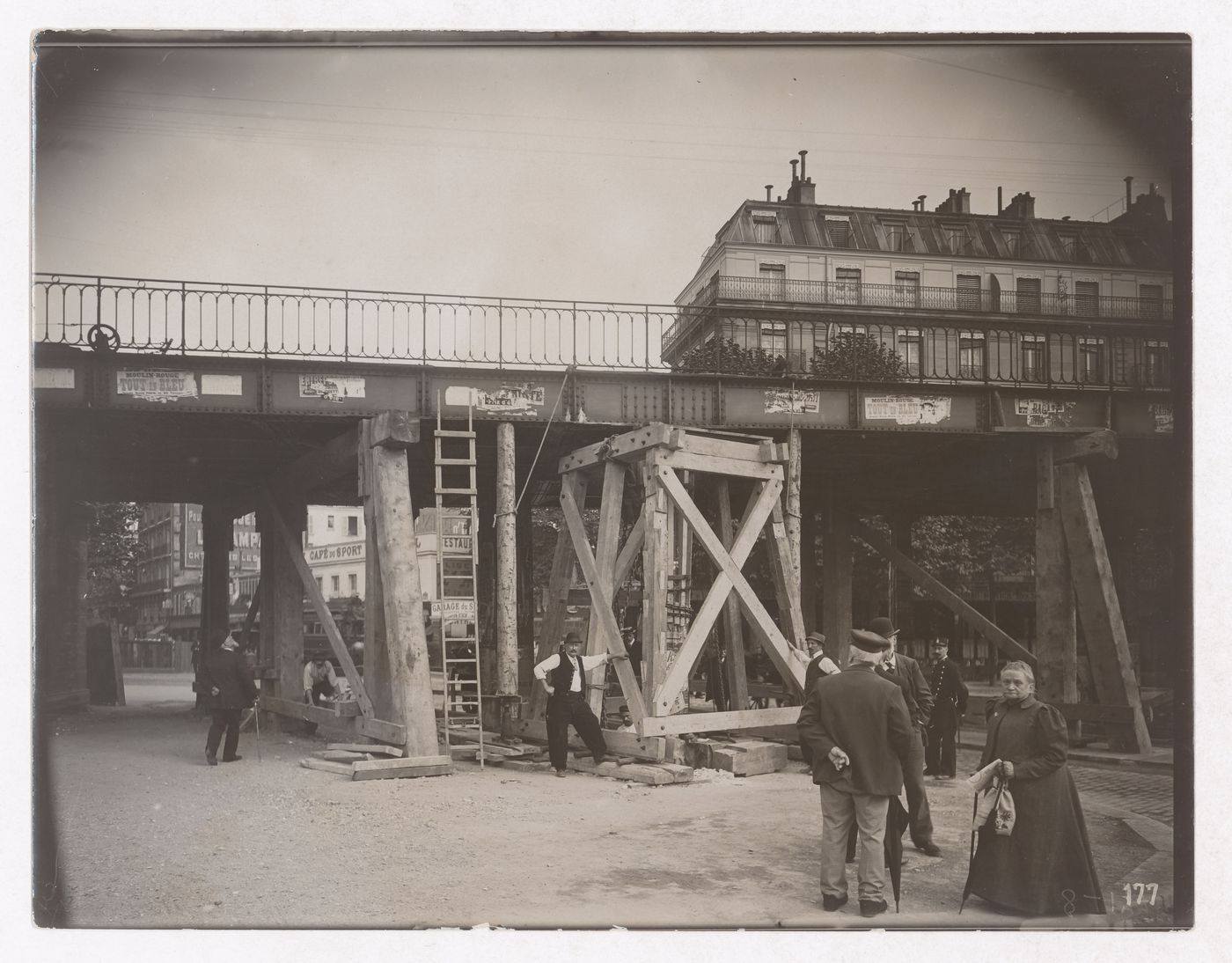 Construction of the Paris Metro, detail, exterior view with train on raised bridge with people standing under the bridge, Paris, France