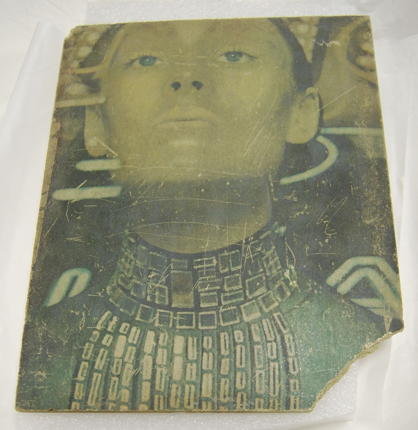 Green sulphur concrete plate with the portrait of a woman