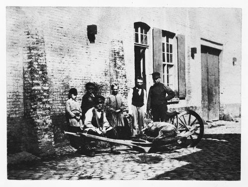 A group of people with a wooden cart carrying a dead pig, France