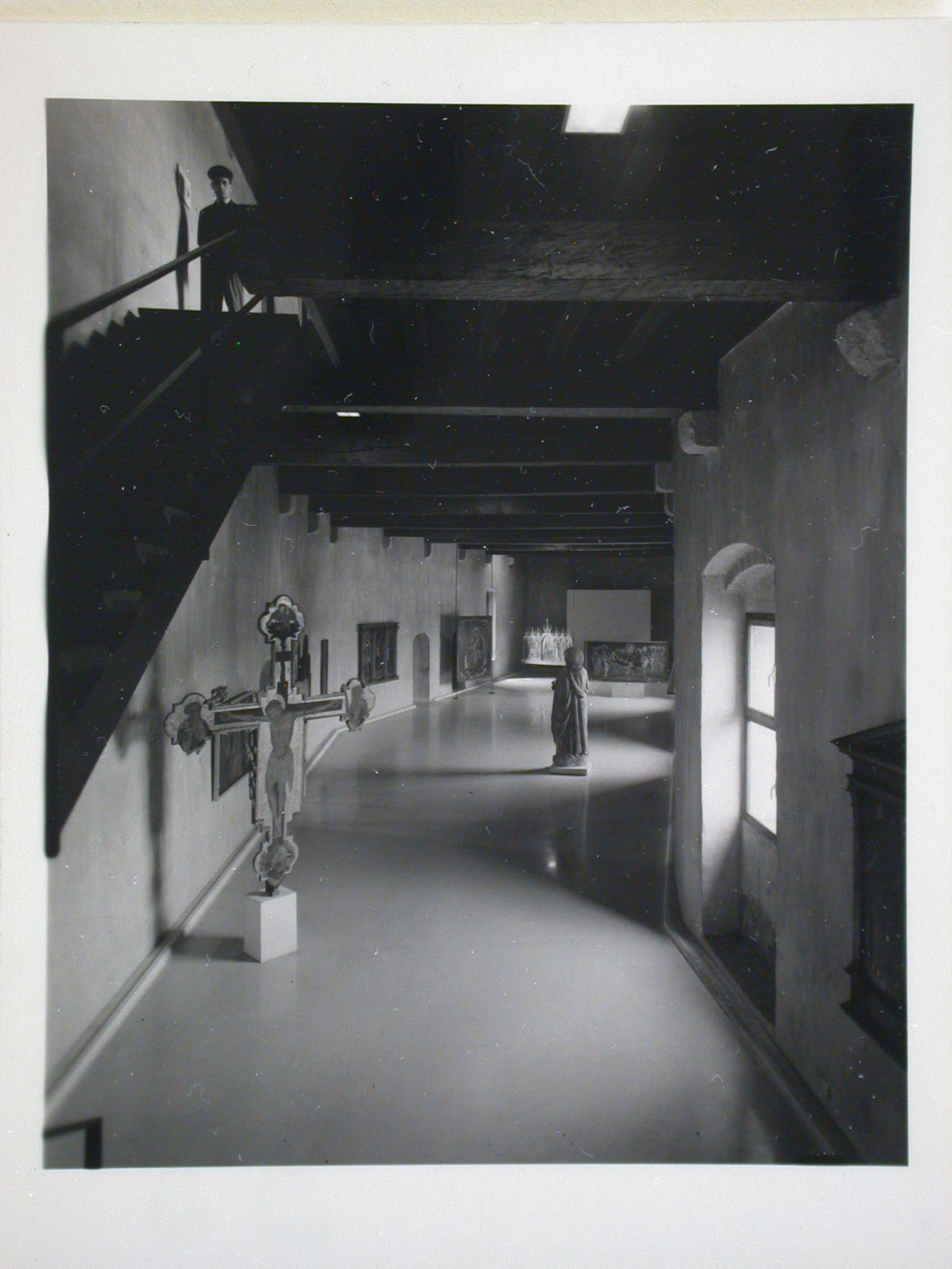 Interior view of a gallery showing a freestanding painted crucifix, a statue and paintings, Museo di Castelvecchio, Verona, Italy