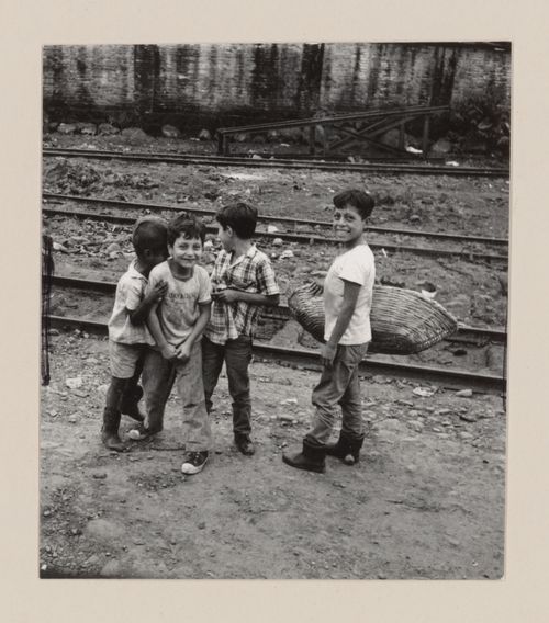 Young boys with basket near a railroad track, South America