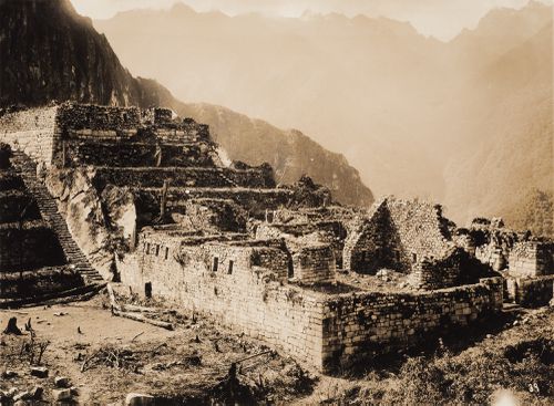 Partial view of the Industrial Sector showing walls, a staircase and buildings, including the Double Masma at the right, Machu Picchu, Peru