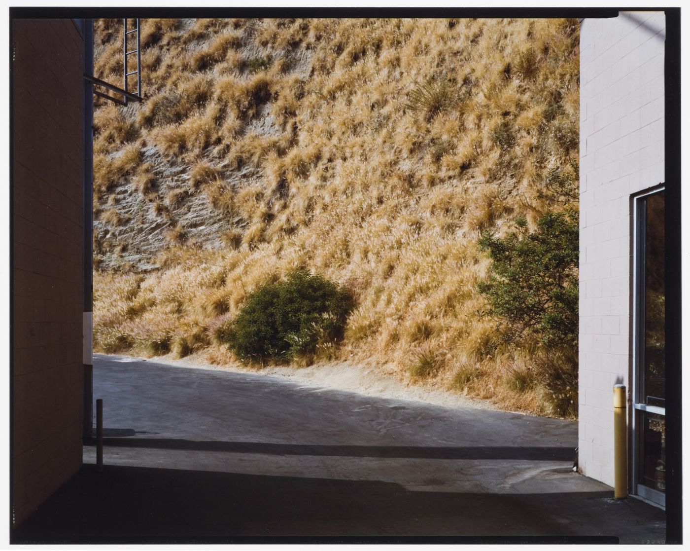 View of a road with a steep hill  in the background with dry grass on it, Sunset Strip, Hollywood, California