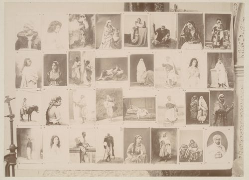 View of large panel with pinned studio portraits, possibly a photographer's portfolio, with a metal stand on the left side, Algiers, Algeria