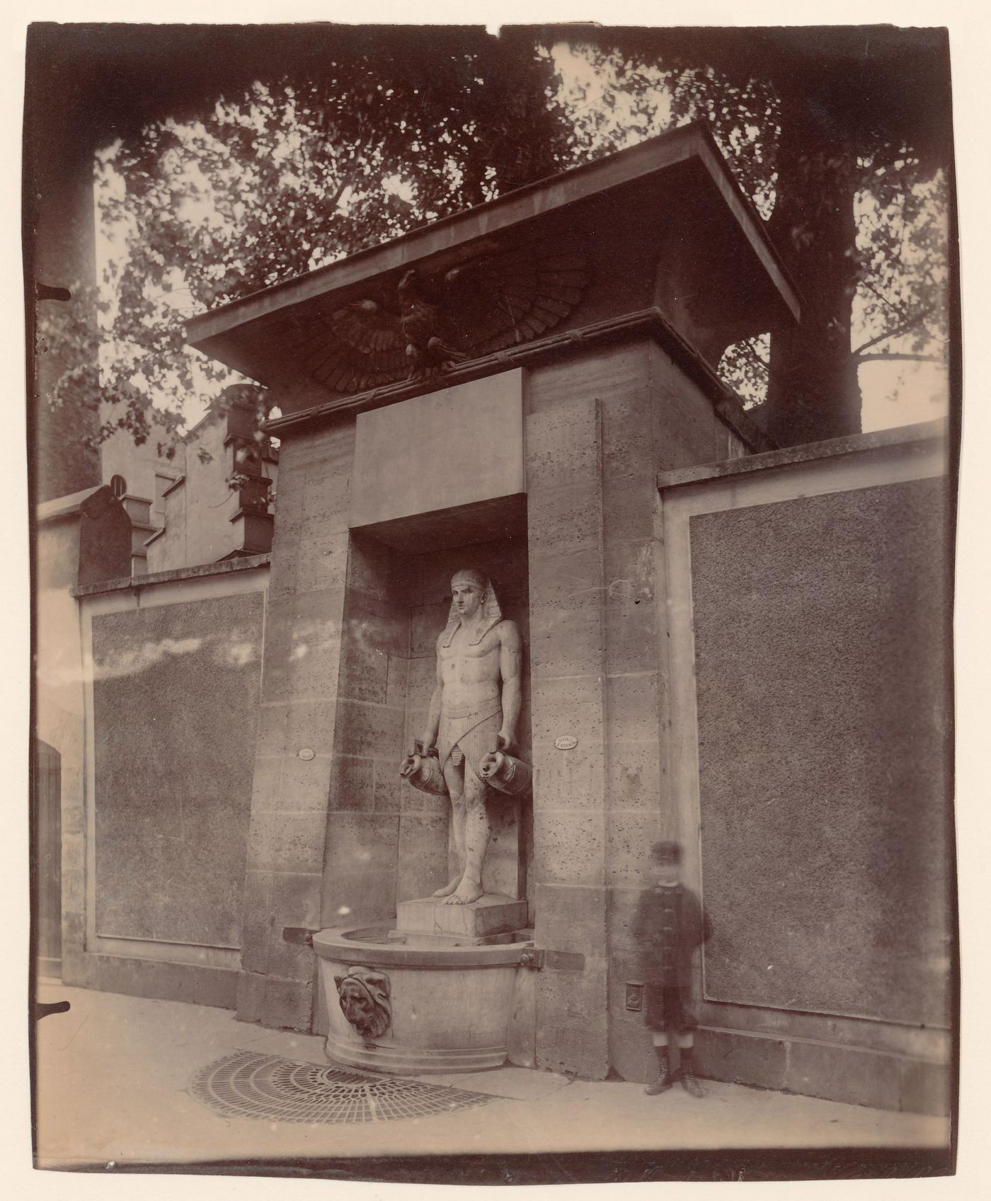 Egyptian style fountain, rue de Sèvres, with "ghost" of boy, Paris, France