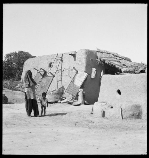 Woman and child in front of a rural house in Chandigarh's area before the construction, India
