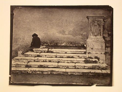 Base of exterior stairway, with seated figure, Italy
