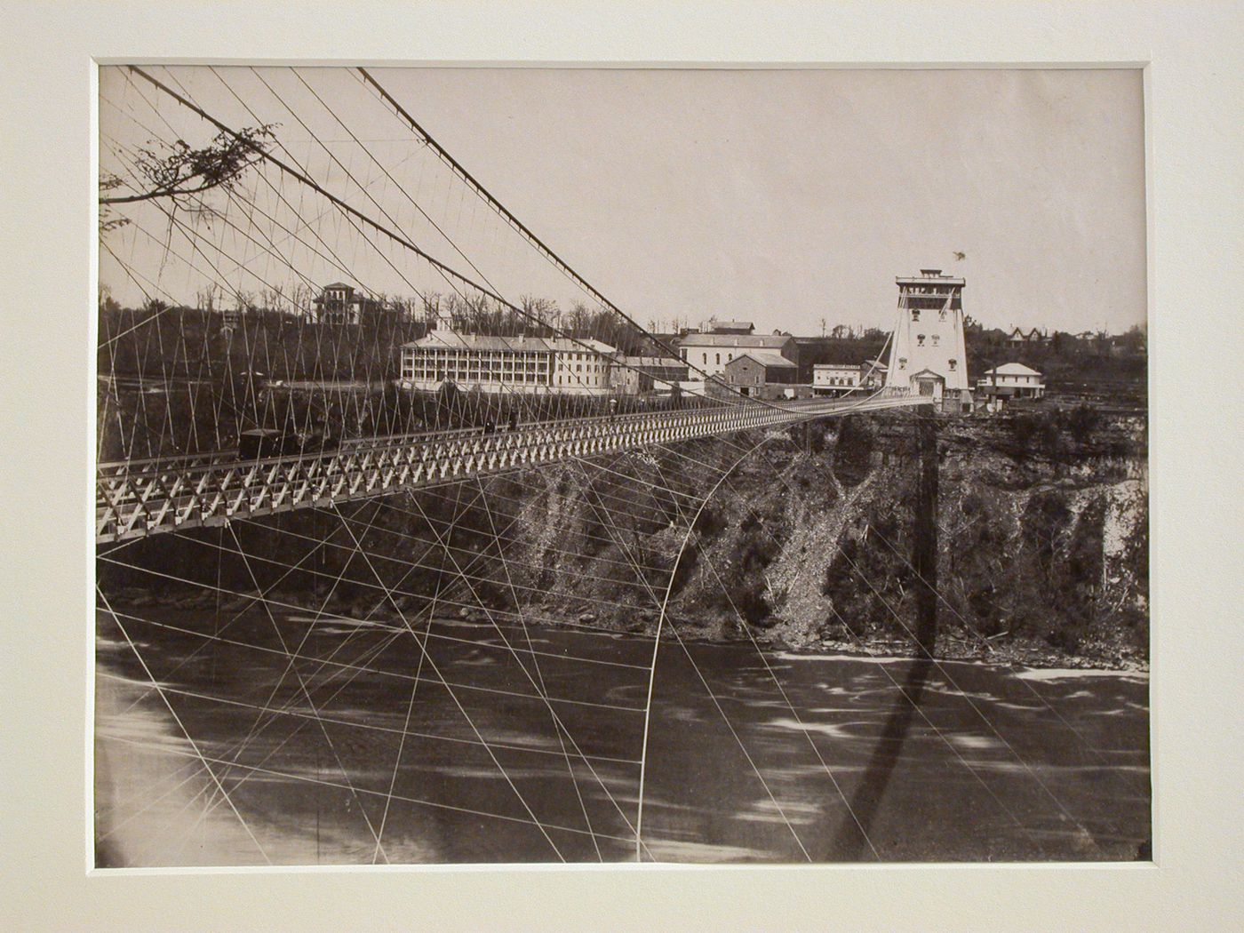 Niagara Suspension Bridge over the Niagara River showing tower at one end and people crossing, Niagara Falls, New York