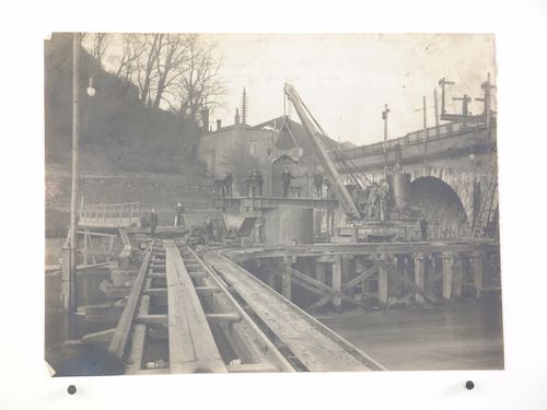 View of men posing with crane on railway bridge under construction