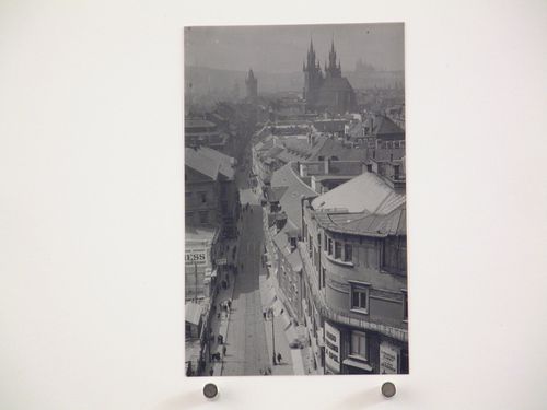 View from above down a narrow street, with large church or cathedral in distance, Prague, Czech Republic