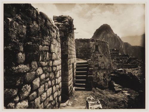 View of the staircase leading to the Torreón, the façade of the House of Ñusta [princess], the wall of an unidentified building in the left foreground, and the Industrial Sector in the background, Machu Picchu, Peru