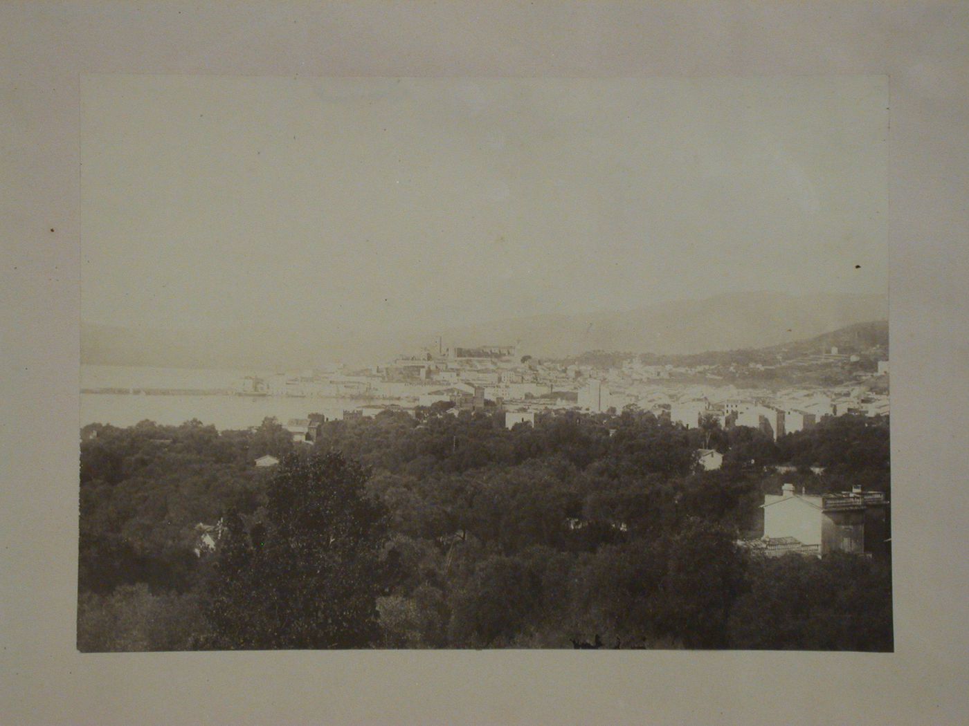 Distant view of a city on a bay showing a church [?] and other buildings, France [?]