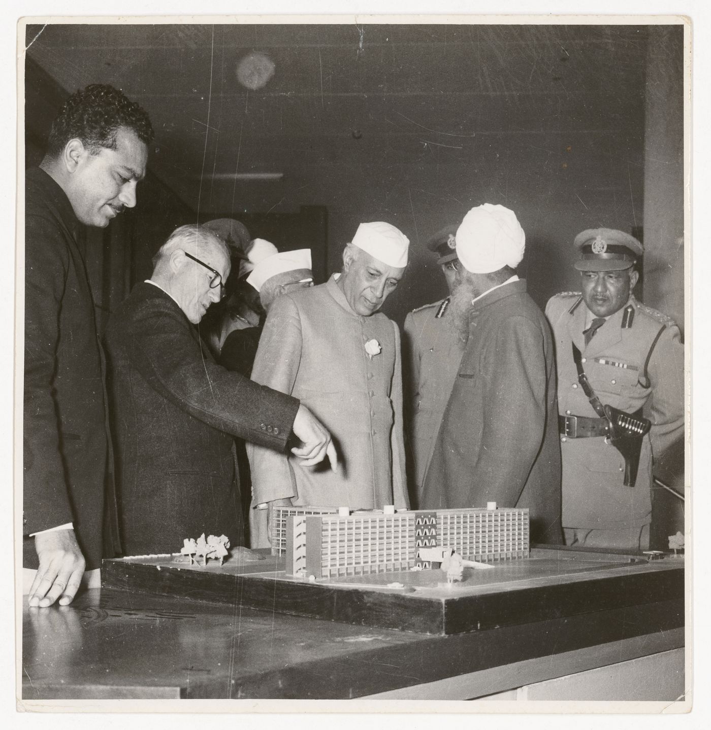 Photograph of Prime Minister Jawaharlal Nehru, Pierre Jeanneret and others looking at a model.