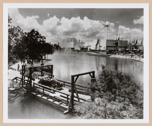 View of the Ford Motor Company pavilion from across a river showing an automobile and fountain, 1939-1940 New York World's Fair, New York City, New York