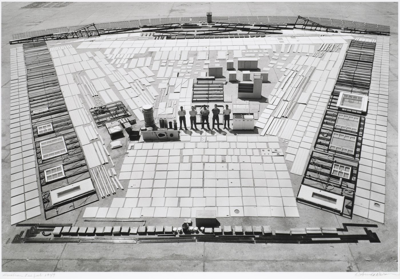 Group portrait of workmen standing admidst prefabricated parts of a Lustron house layed-out for construction, Columbus, Ohio, United States