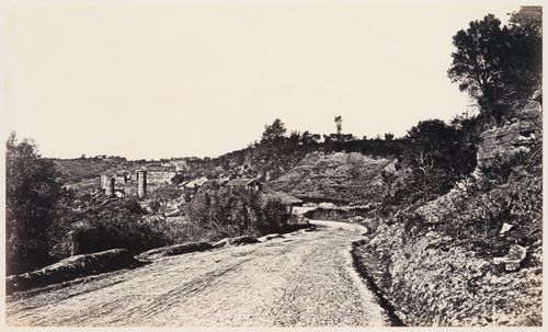 View of a road with a town in the distance in the Roman Campagna, Italy