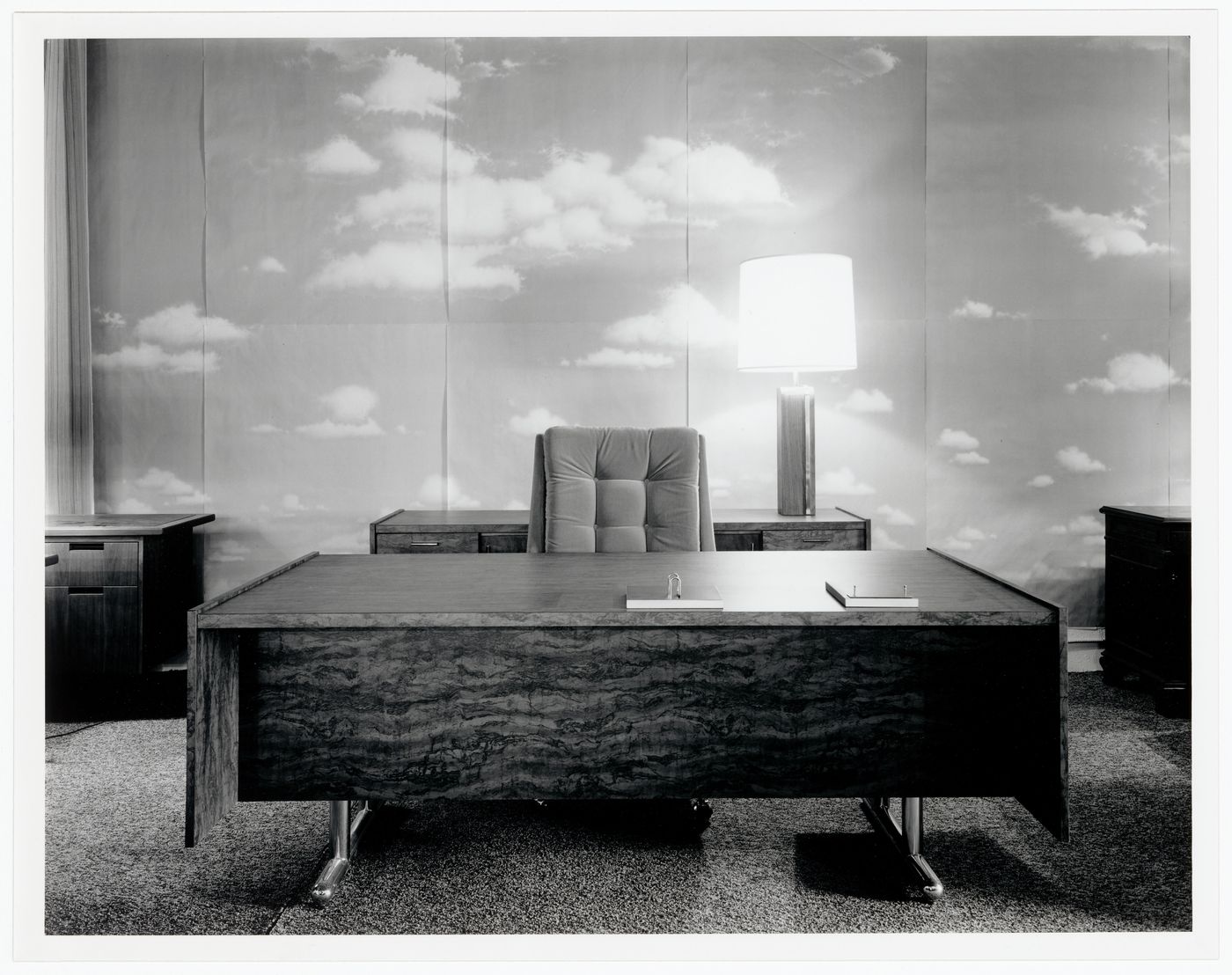 Office Environment : office with photographs of clouds and sky on wall behind desk