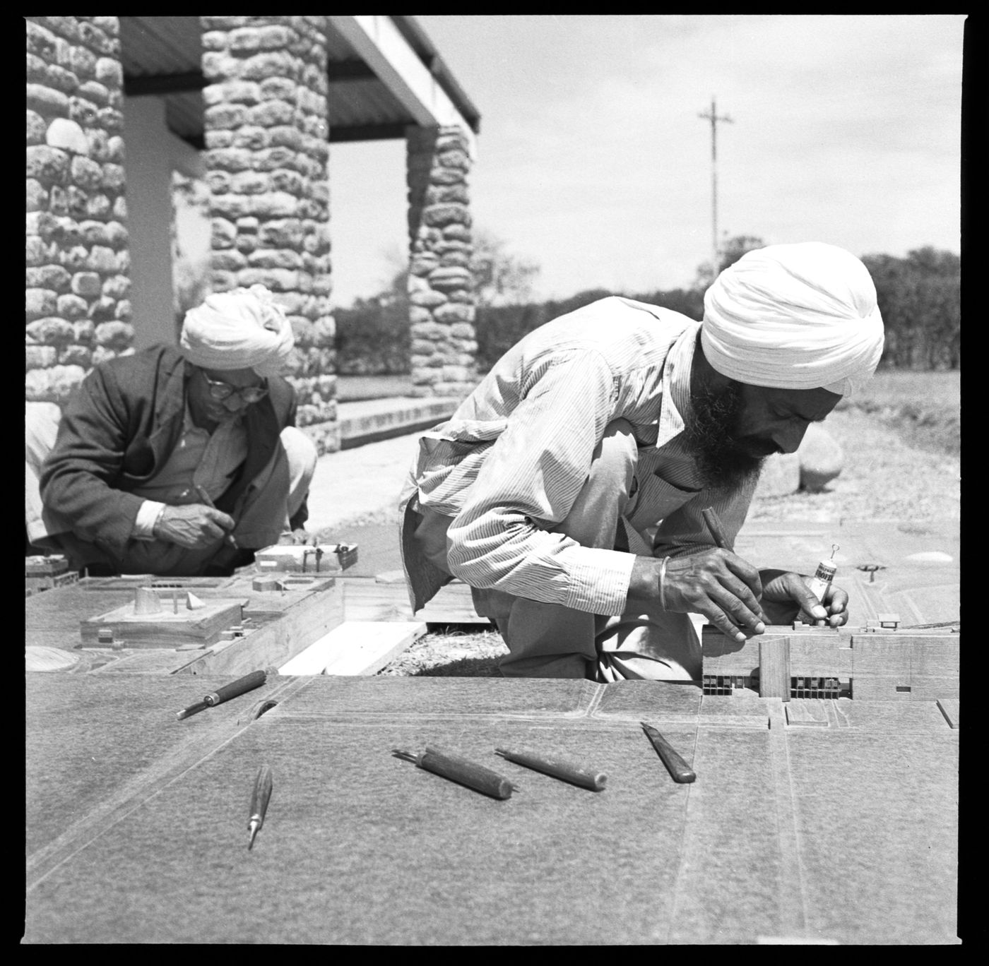 Portrait of model makers, Rattan Singh and Dhani Ram, at work on the model for Capitol Complex, Sector 1, Chandigarh, India