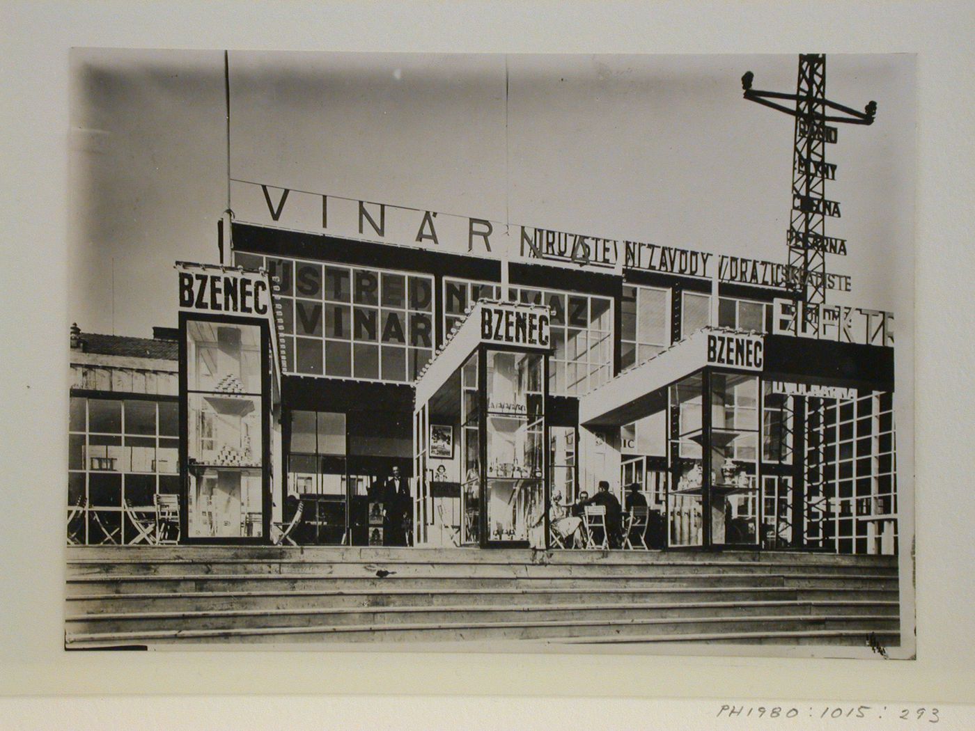 View of an exhibition pavilion showing exterior display cases, signs and outdoor café