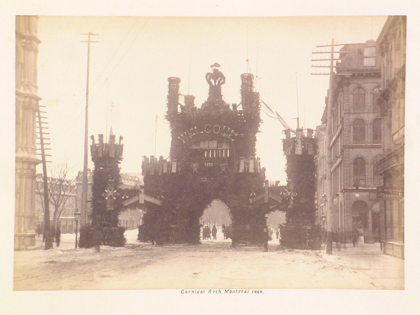 View of a temporary arch constructed of tree boughs and sleds over a wooden structure, Winter Carnival of 1887, Montréal, Québec