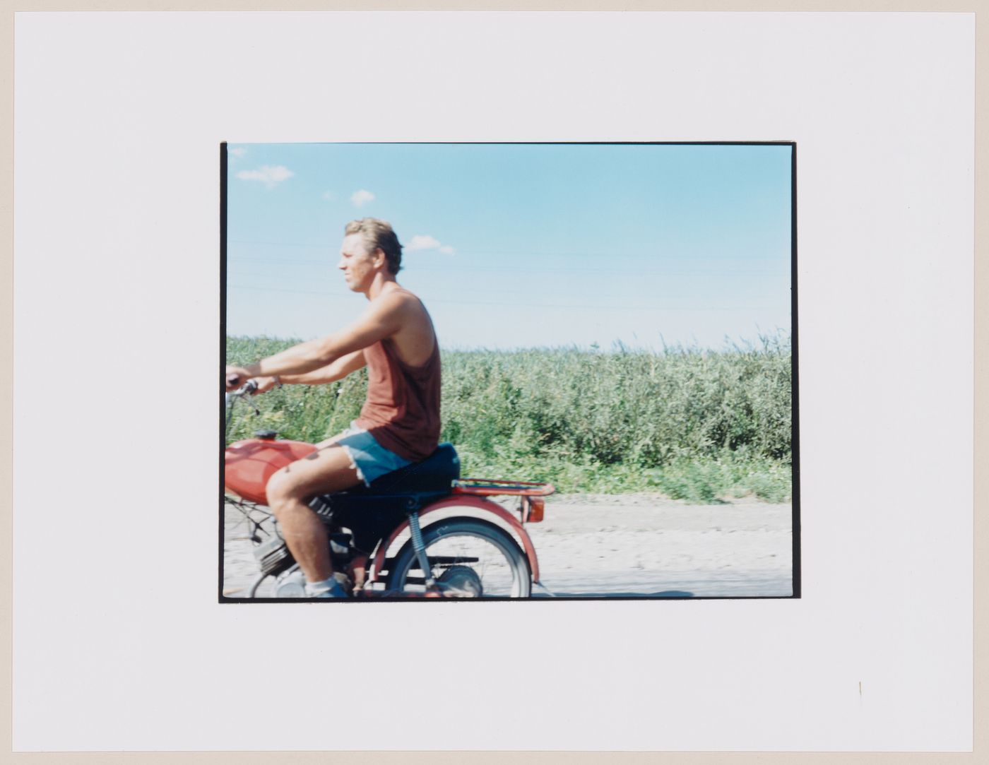Portrait of a man riding a motorcycle and cropland, Mamonovo, Kaliningradskaia oblast', Russia (from the series "In between cities")
