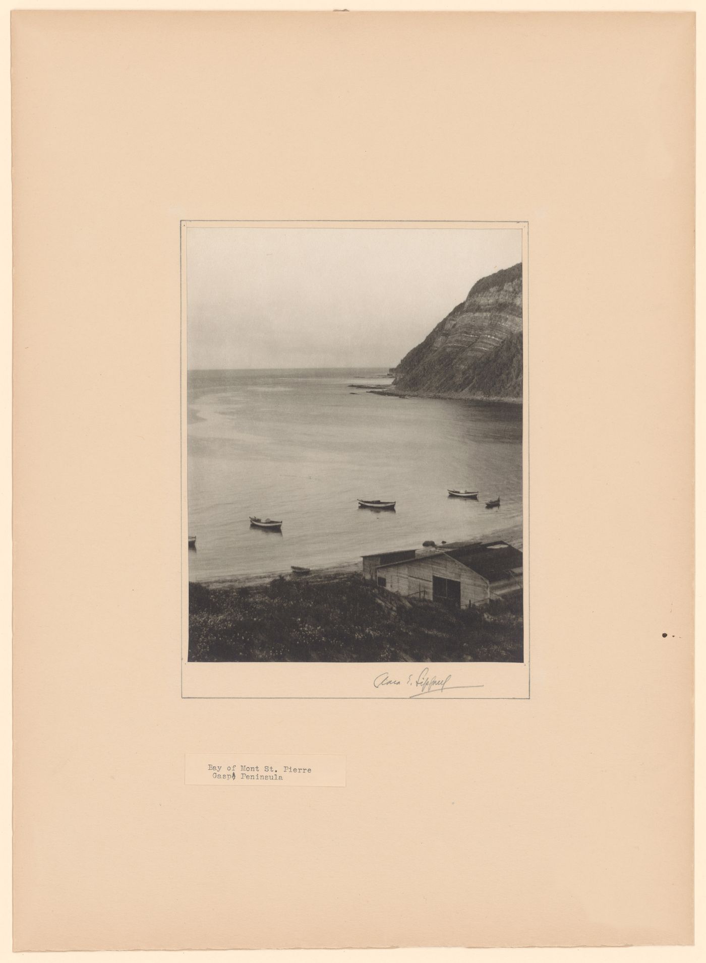 View of Anse de Mont-Saint-Pierre showing sheds and boats in the foreground, Gaspé Peninsula, Québec, Canada