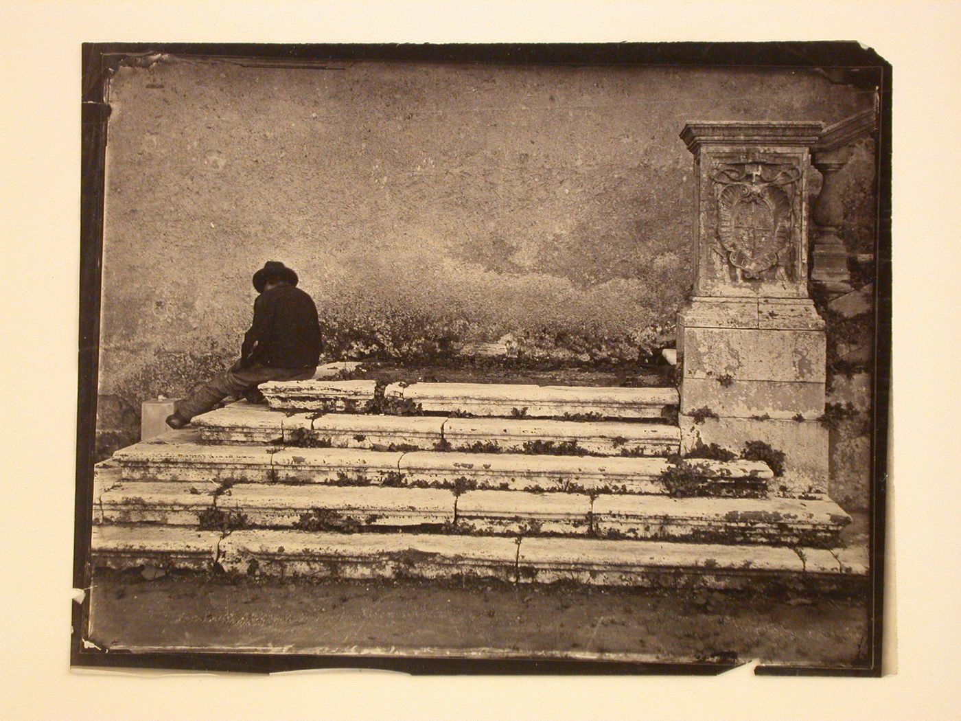 Base of exterior stairway, with seated figure, Italy
