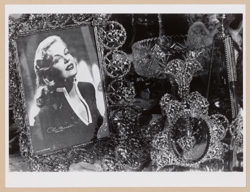 Close-up view showing a framed photograph of Cleo Moore (Queen of the B movie "Bad Girls") surrounded by ornamented objects, Hoboken, United States
