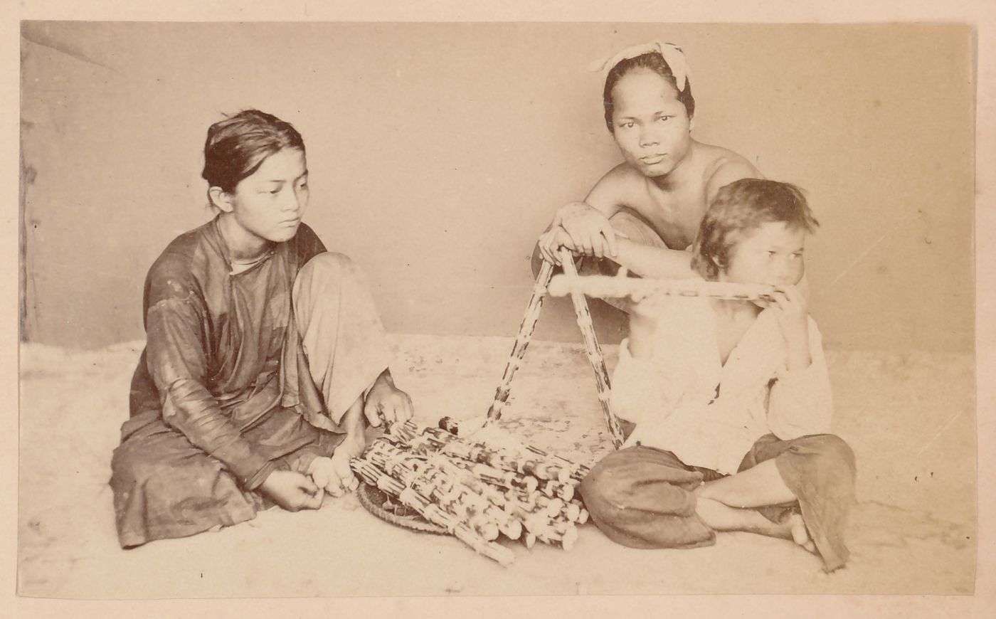 Group portrait of three people, probably in Cochin China (now in Vietnam)
