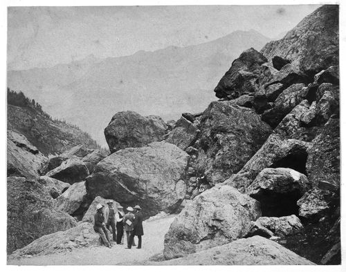 View of rock formations with five standing figures in the foreground, Gavernie, France