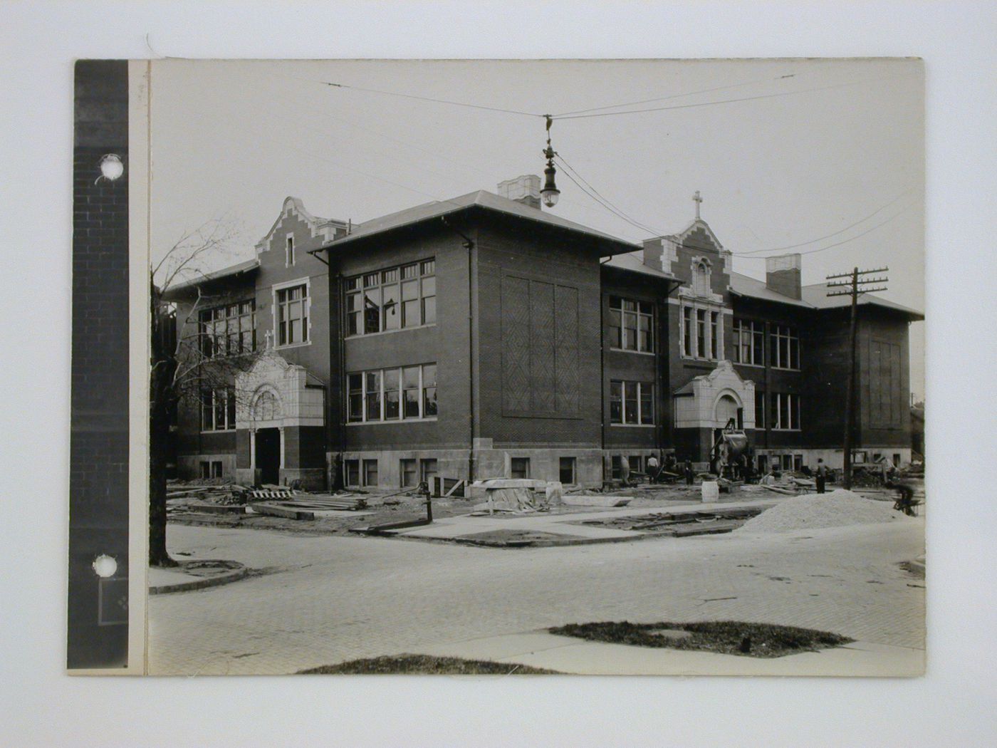 Brick school with construction crew working in yard, Midwest