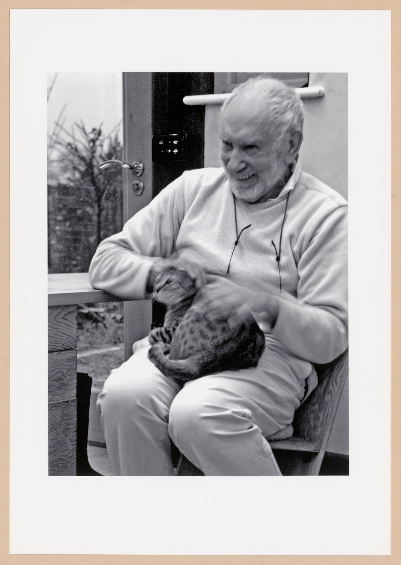 Photograph of Lionel March petting a cat