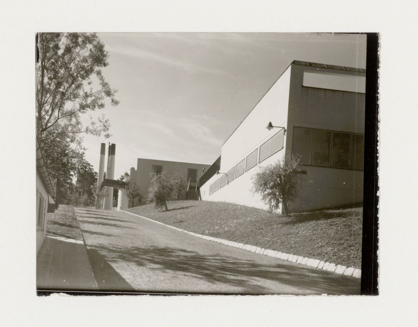 View of the rear façade of Woodland Crematorium showing the driveway, the area for coffin reception and the crematorium chimneys in the background, Stockholm