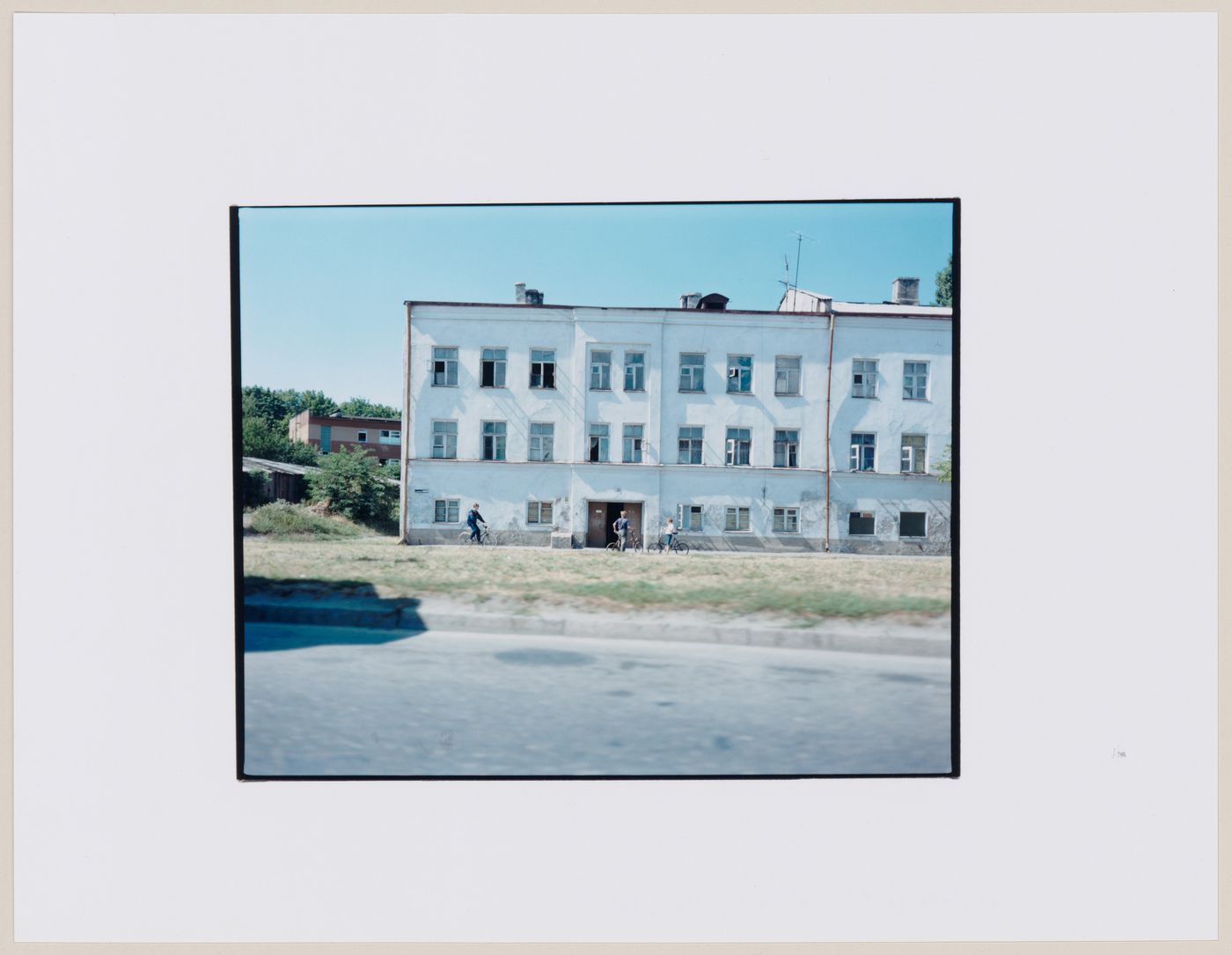 View of buildings, a street, and people on bicycles, Kaliningrad, Kaliningradskaia oblast', Russia (from the series "In between cities")