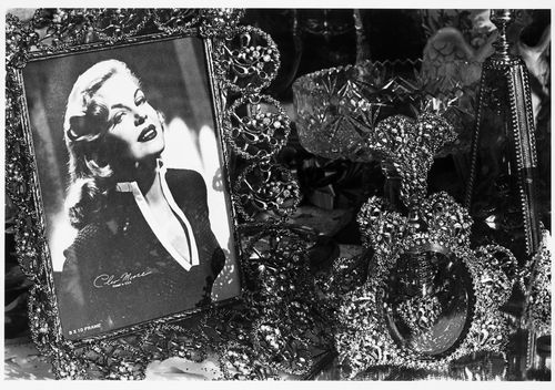 Close-up view showing a framed photograph of Cleo Moore (Queen of the B movie "Bad Girls") surrounded by ornamented objects, Hoboken, United States