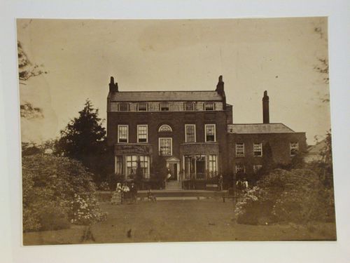 View of a house from the back, with 8 people in the garden, England ?