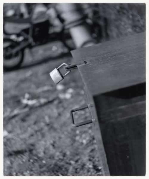 View of a box or cabinet with an attached lock showing a motorcycle in the background, Berlin, Germany, from the artist book "The Potsdamer Project"