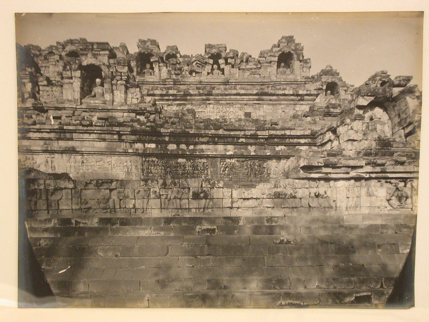 View of the temple of Borobudur taken from one of the lower levels looking up, showing relief panels and statues of the Buddha in niches, Borobudur, Indonesia