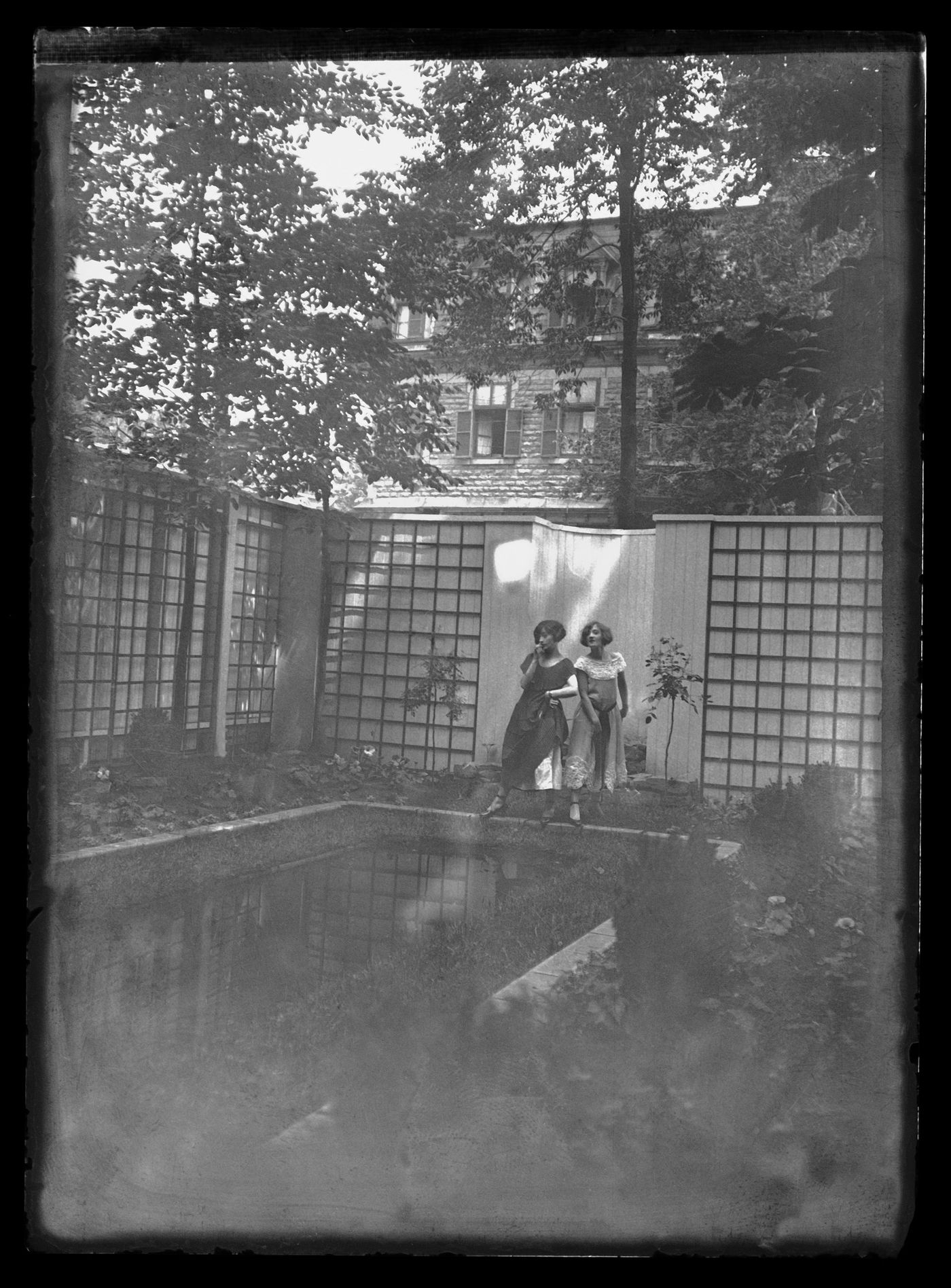 Portrait de Clorinthe et Cécile Perron posant dans le jardin du studio d'Ernest Cormier, Montréal