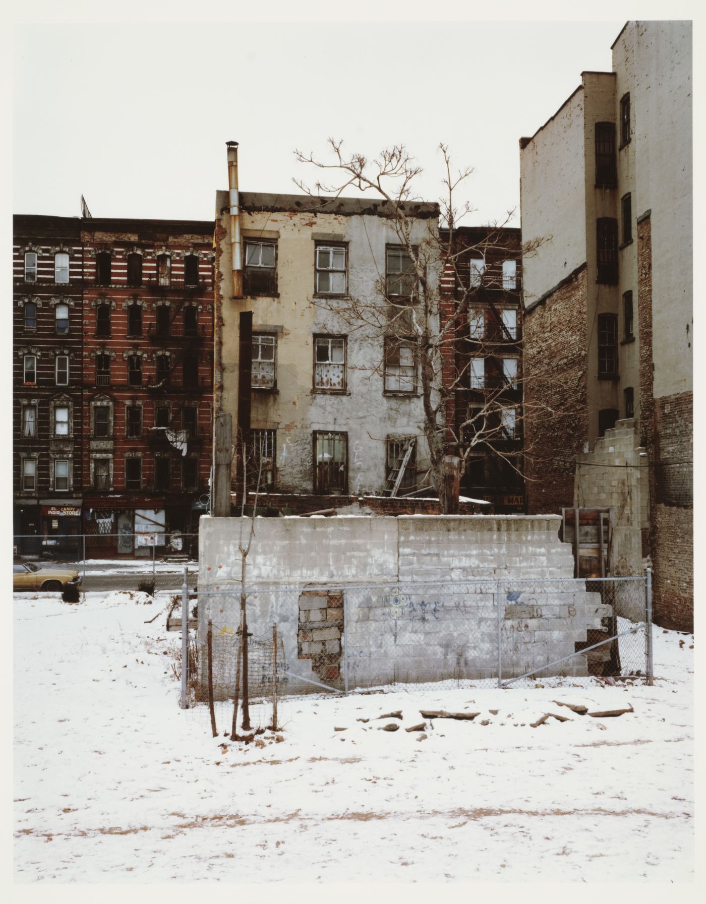 East 9th Street, empty lot with stone walls enclosed by chain link fence in snow, New York City, New York