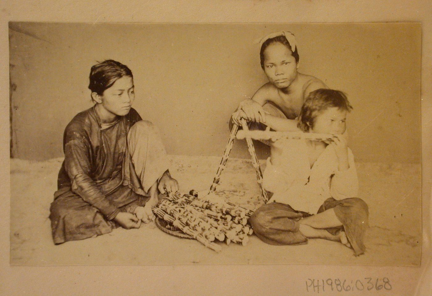 Group portrait of three people, probably in Cochin China (now in Vietnam)
