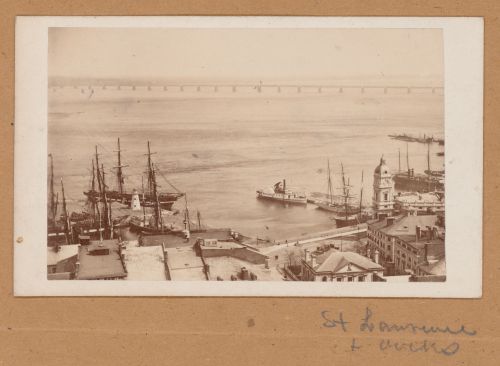 View of the Port of Montréal showing a dockyard, ships, the Maison de la Douane and the Édifice de la compagnie d'assurances Royale (now demolished) with Victoria Bridge in the background, Canada (now Québec, Canada)