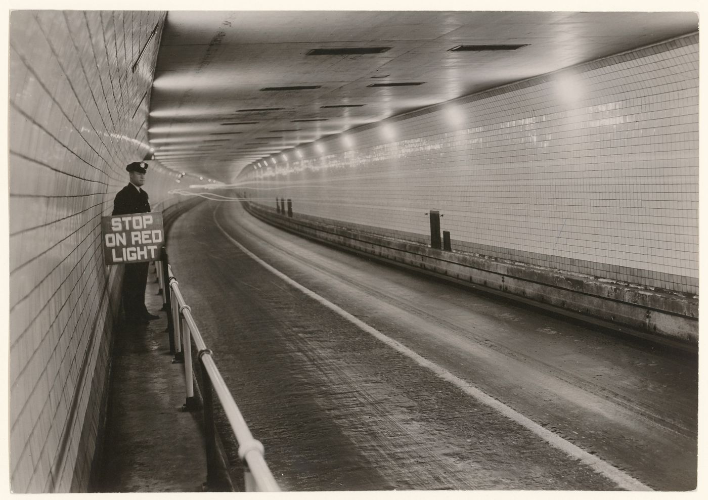 Holland Tunnel, interior view with guard on left holding stop sign, New York City, New York