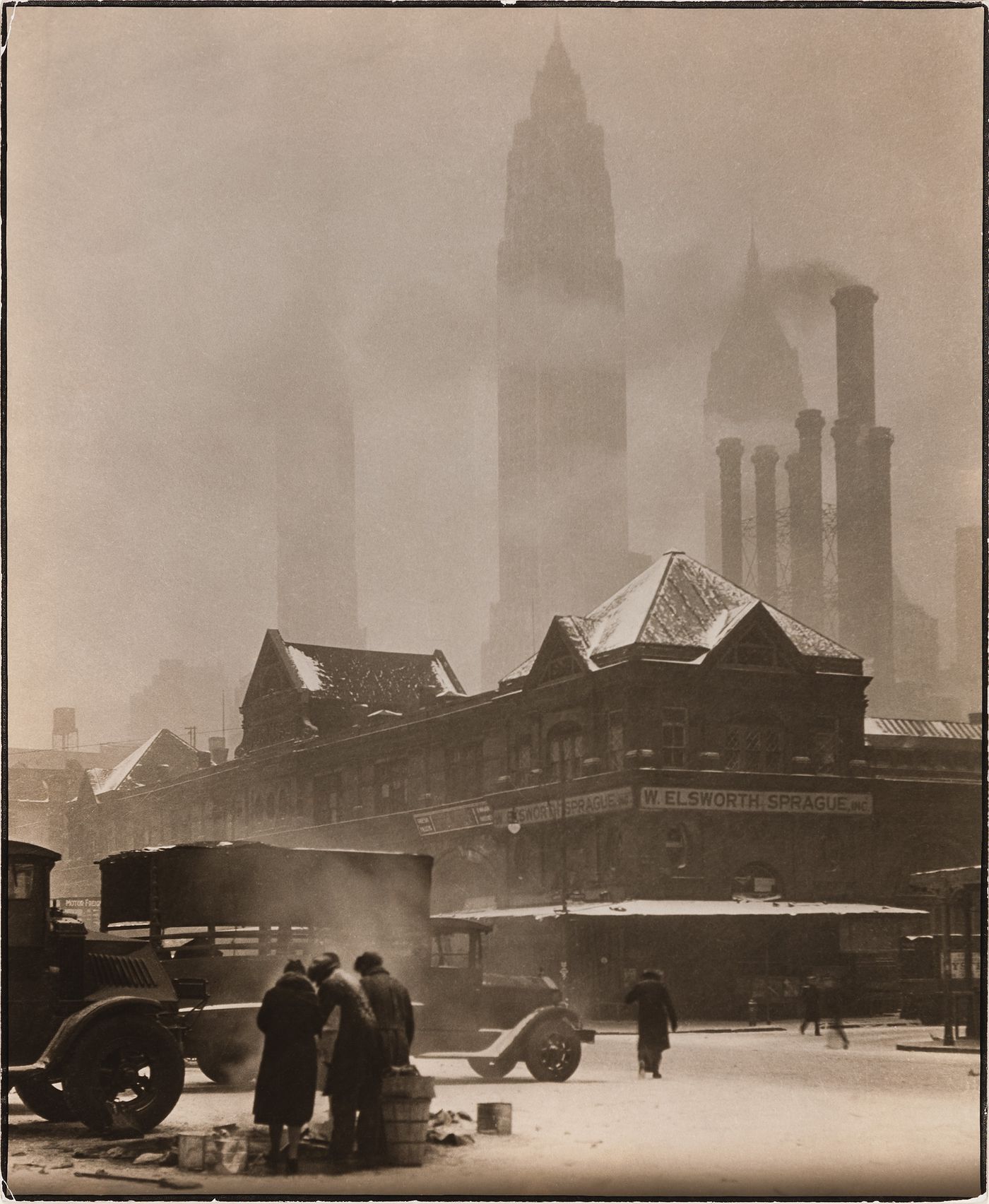 Street scene in snowstorm, W. ELSWORTH SPRAGUE, INC. on corner, skyscraper silhouettes in background, New York City, New York