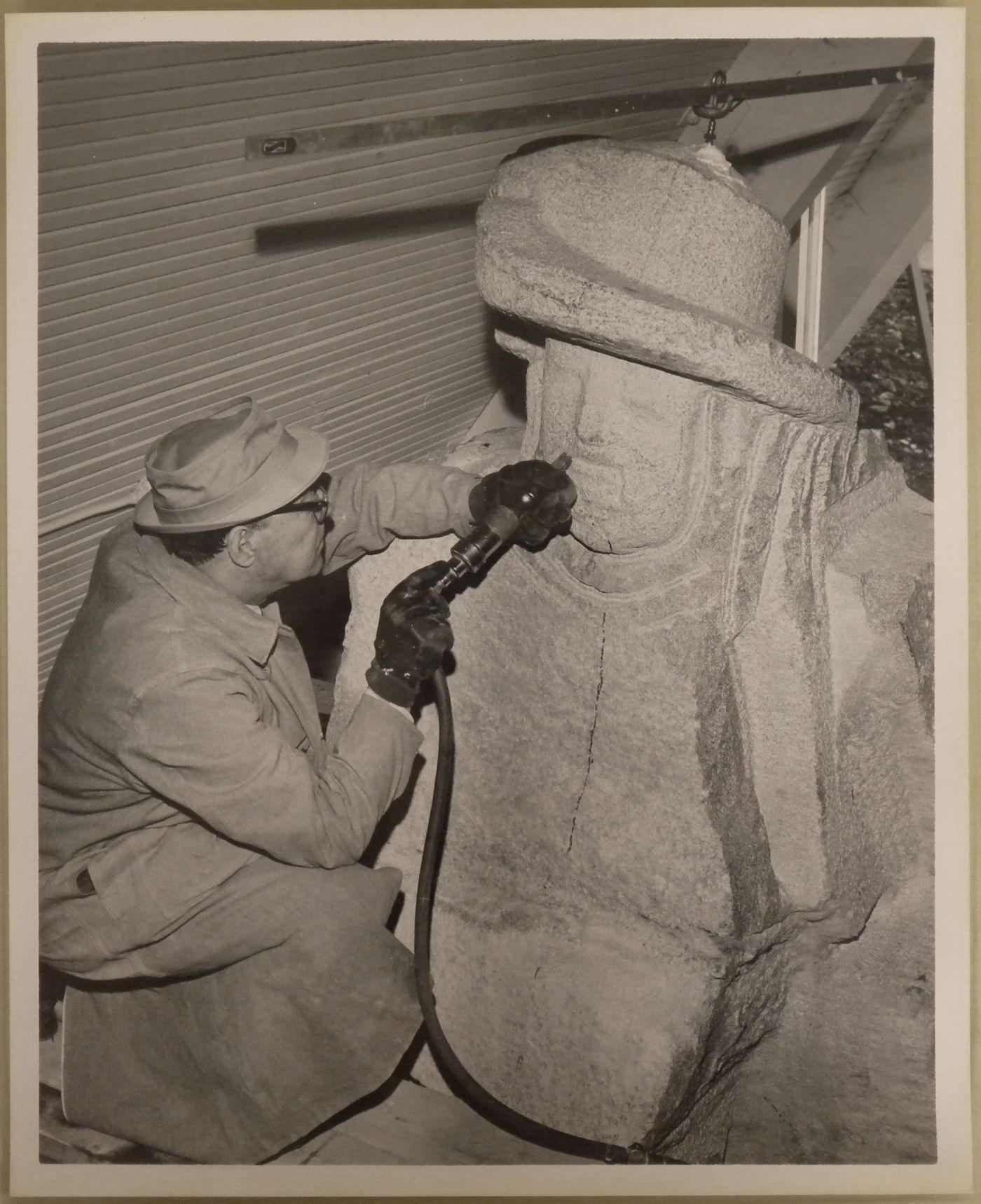 View of Ferdinand L. Weber sculpting the statue of Samuel de Champlain at the Vermont Pavilion, Expo 67, Montreal, Quebec