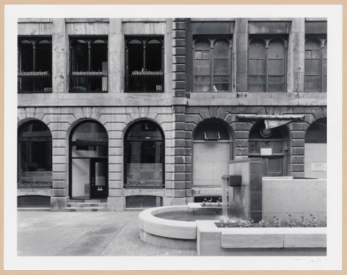 Partial view of the principal façade of Cours Le Royer with a fountain in the foreground, Montréal, Québec