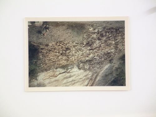 View of a man sitting by rocks on a mountain