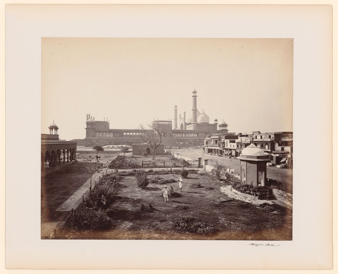 View of the Jami Masjid from the south showing commercial buildings on the right and a garden in the foreground, Delhi, India
