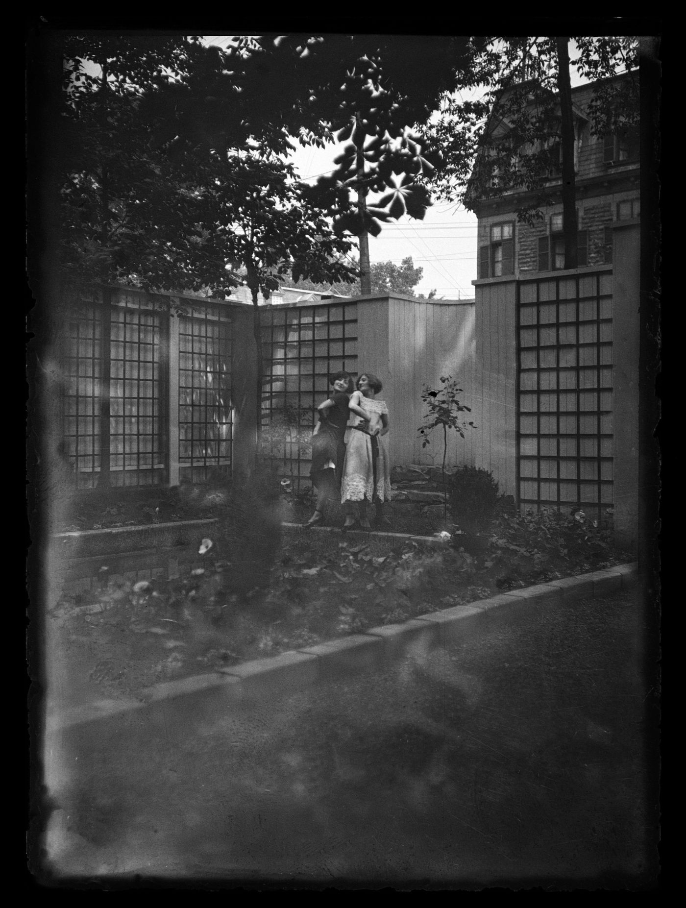 Portrait de Clorinthe et Cécile Perron posant dans le jardin du studio d'Ernest Cormier, Montréal