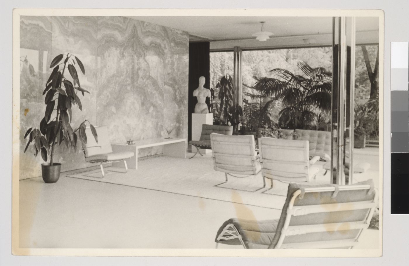 Interior view of the living area looking east showing the onyx wall and a statue on the left and a seating area in the centre, Tugendhat House, Brno, Czechoslovakia (now Czech Republic)